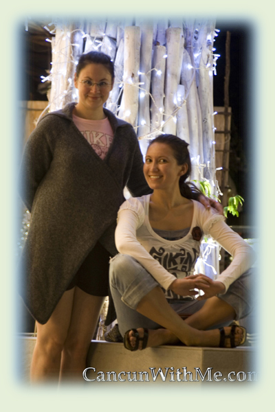 Two friends posing at the lighted tree in Playa del Carmen